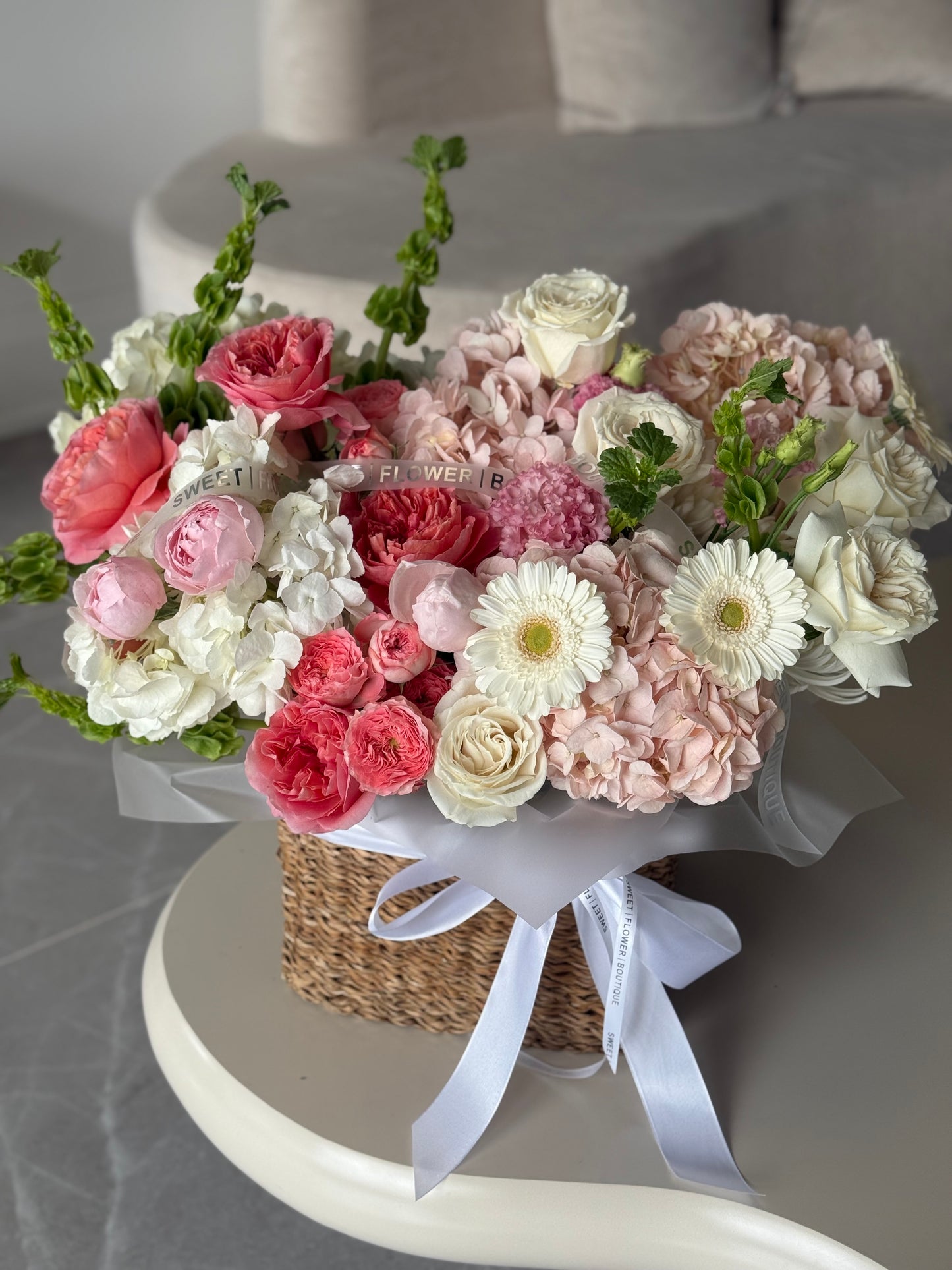 elegant pink and white flower basket with gerberas and ranunculus