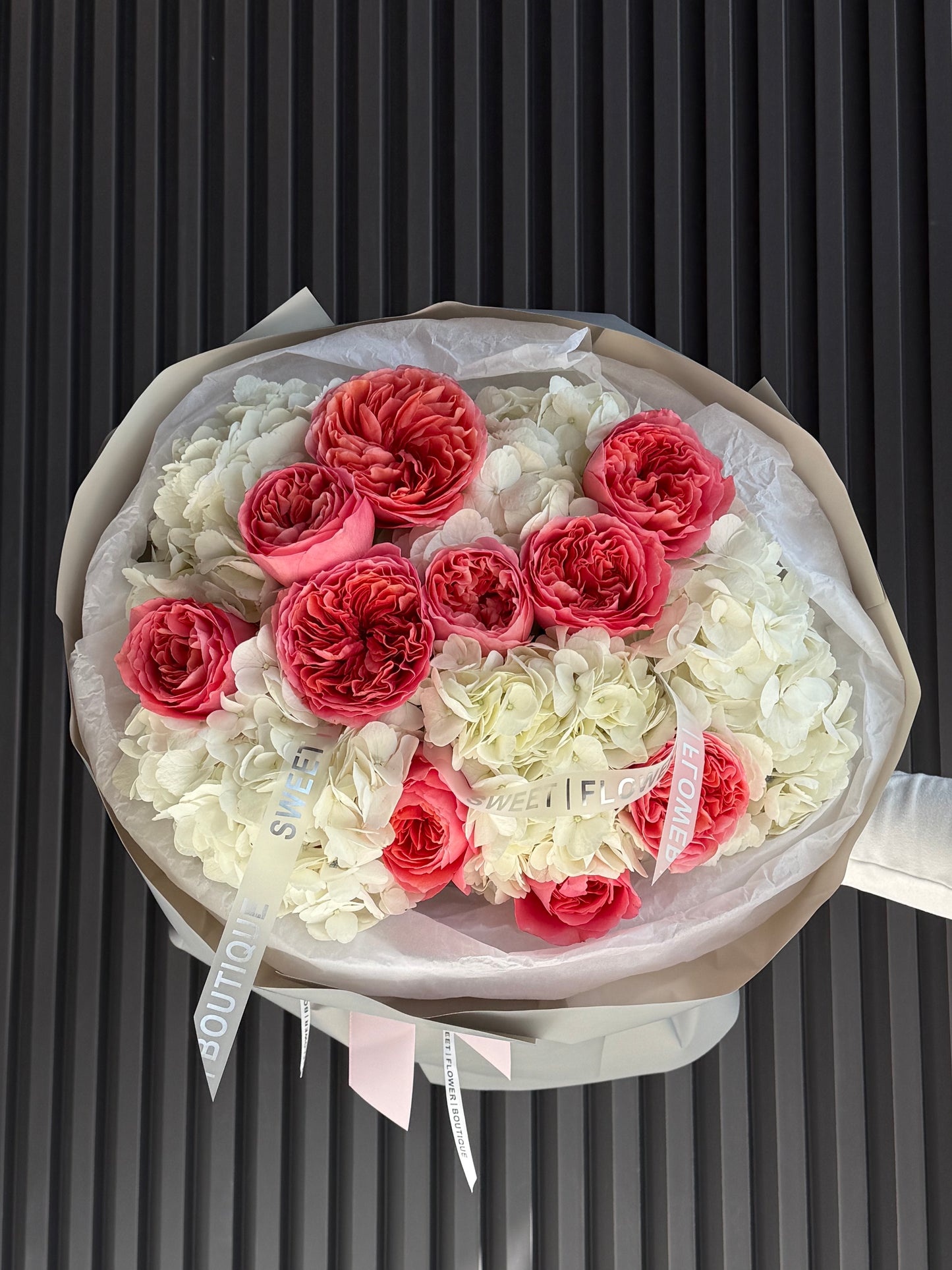 Bouquet of red and white flowers in a clear plastic wrap on a black background