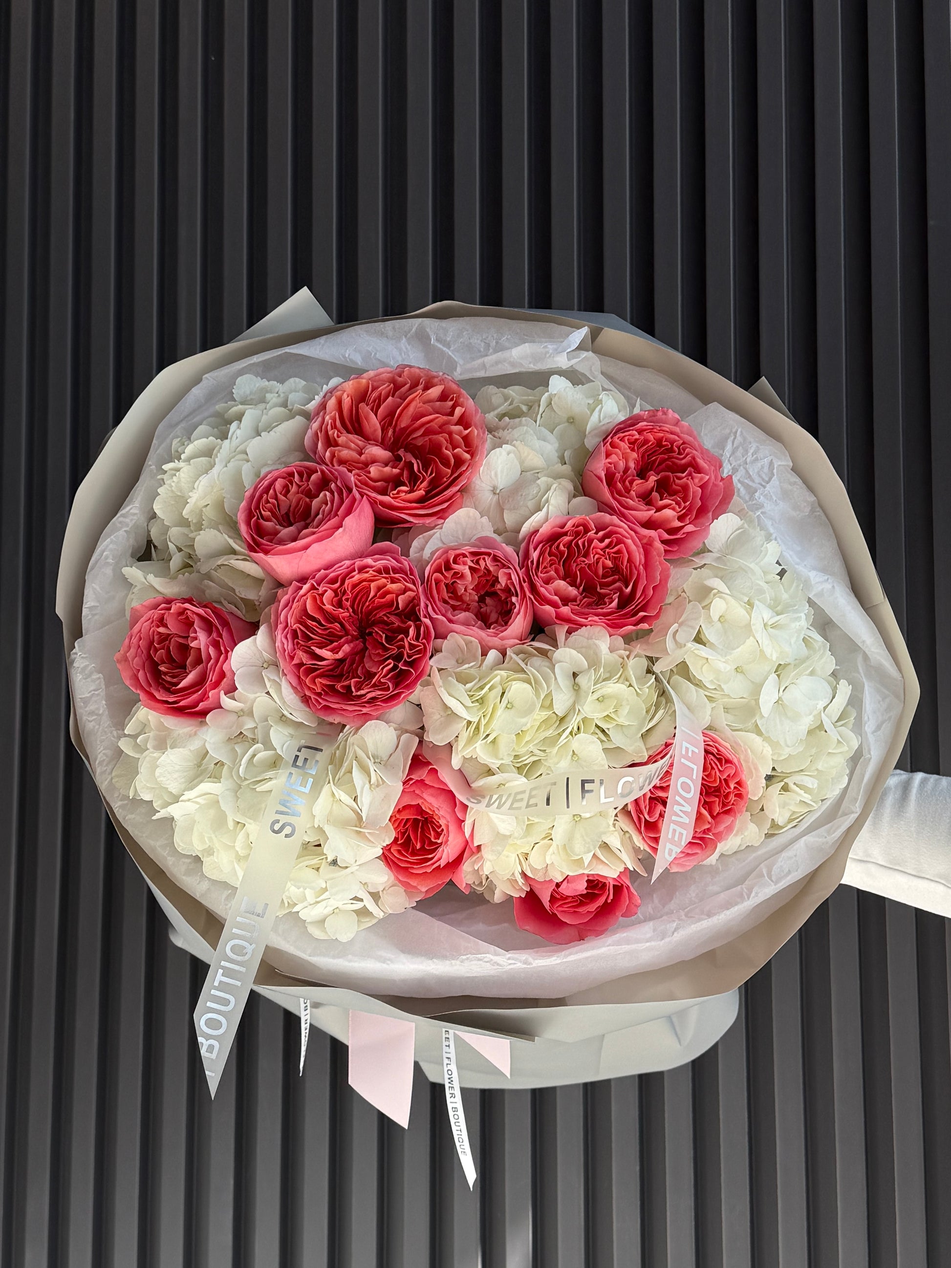 Bouquet of red and white flowers in a clear plastic wrap on a black background