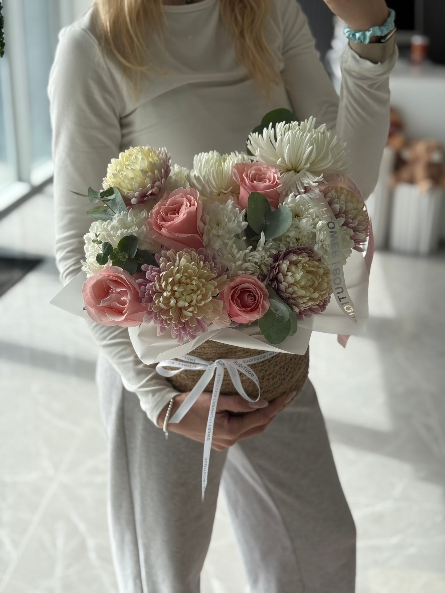 Person holding a bouquet of flowers indoors