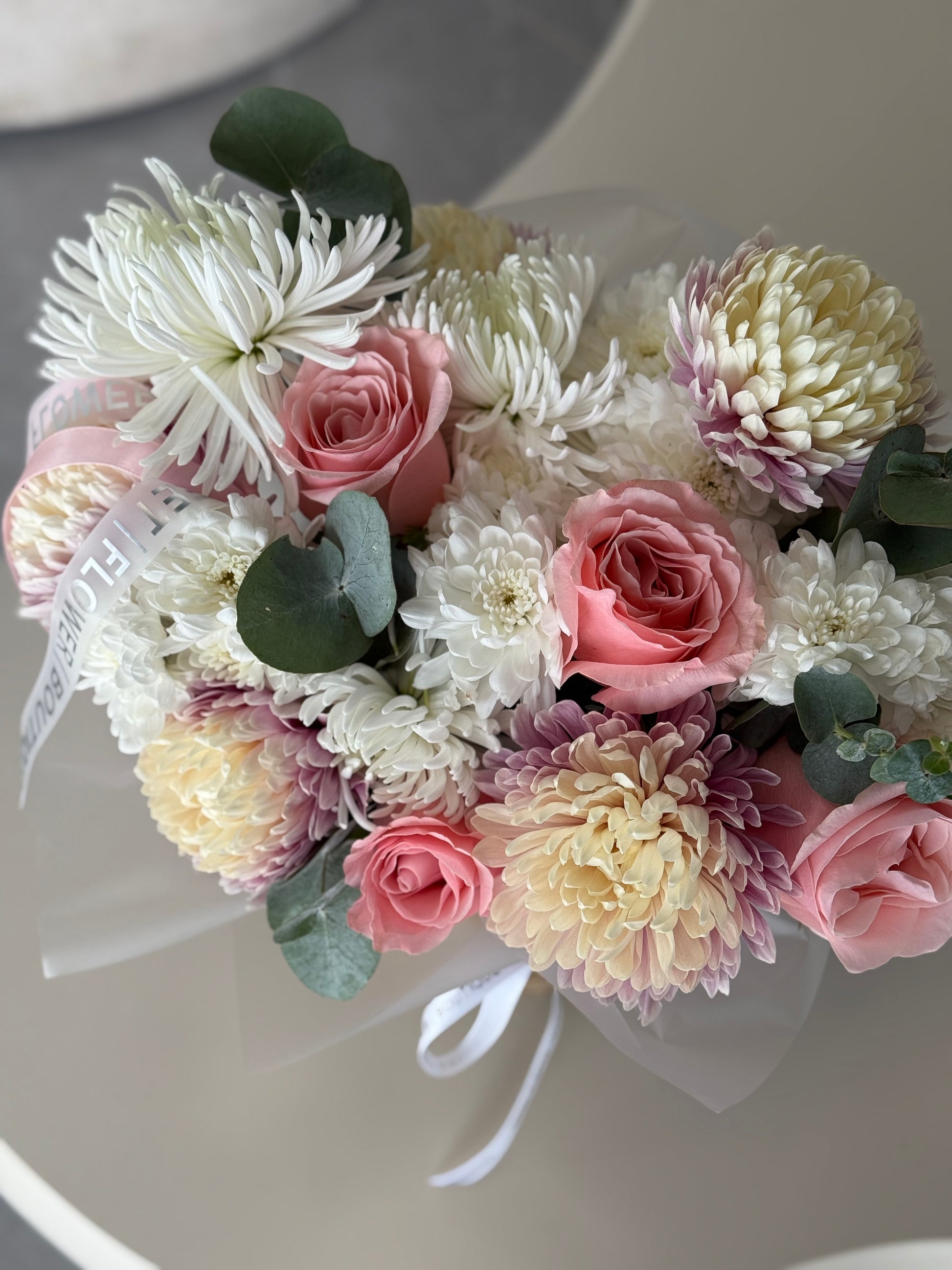 Bouquet of pastel flowers including roses and chrysanthemums on a white background