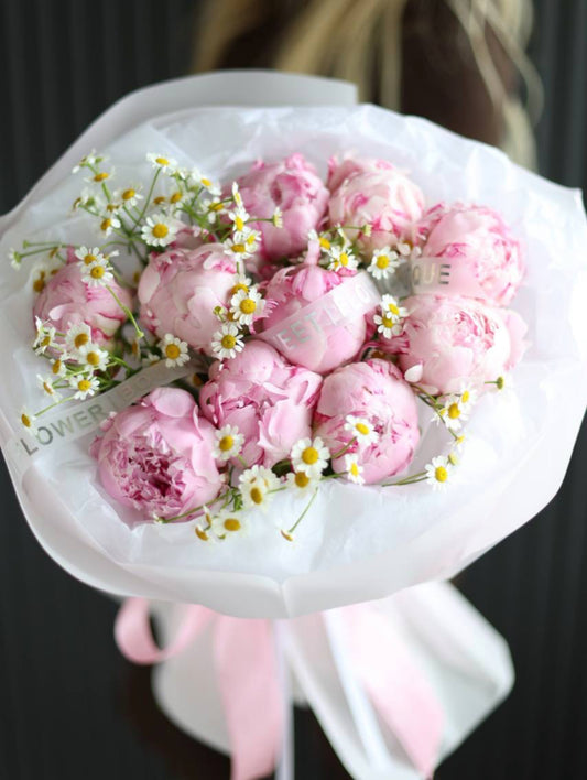 Bouquet of 10 pink peonies with white chamomile flowers in luxury white wrapping