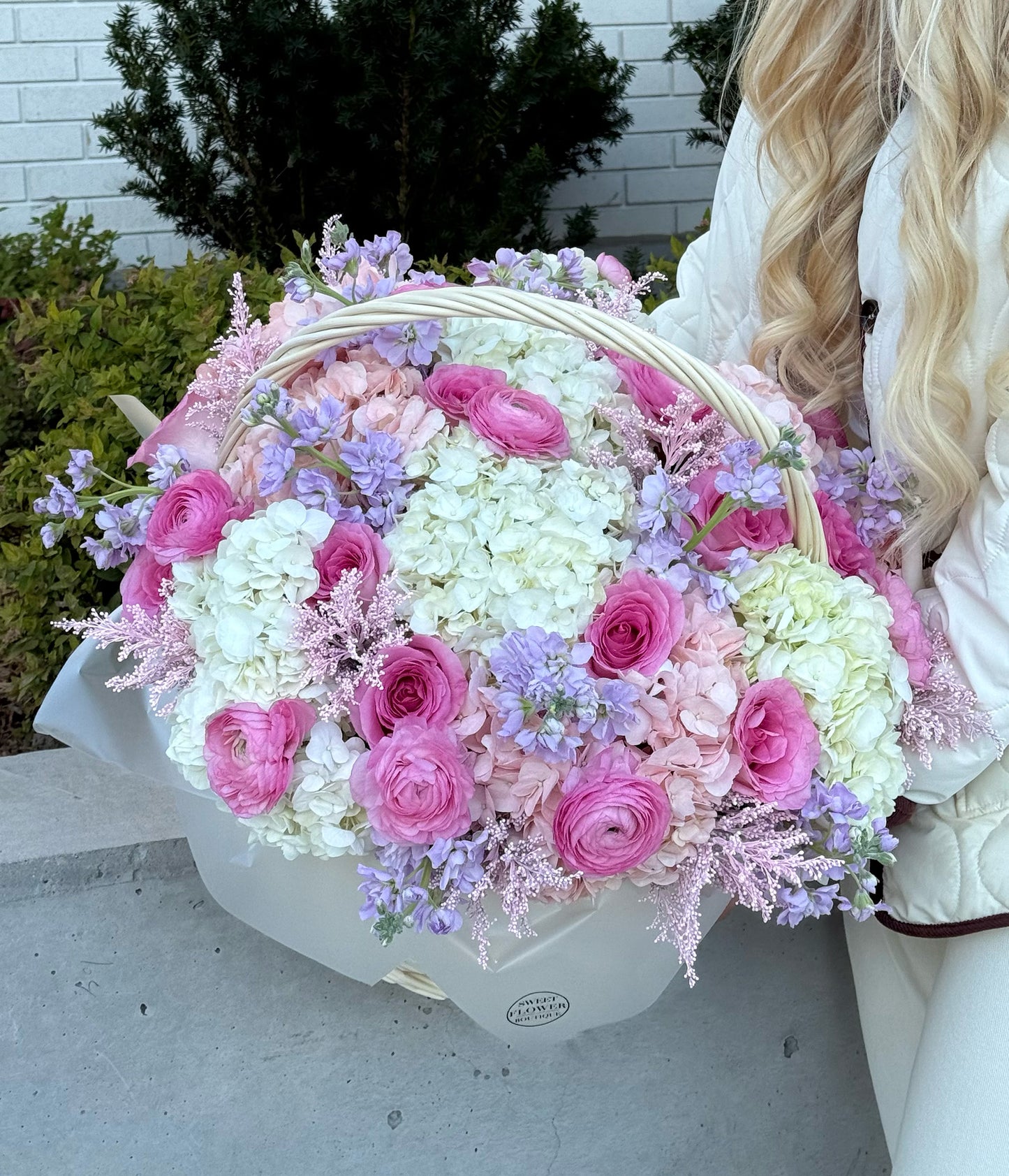 Heart-shaped flower arrangement with pink and white flowers in a decorative box.