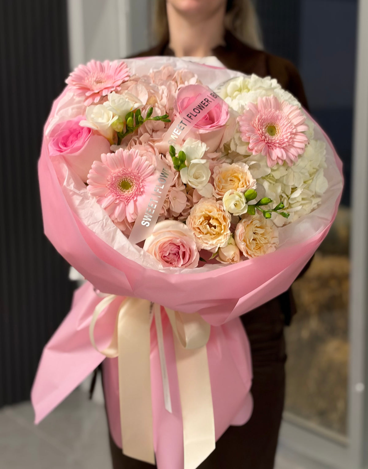 Luxury pink flower bouquet with blush roses, garden roses, pink gerbera daisies, hydrangeas and white freesias, beautifully wrapped in pink paper by Sweet Flower Boutique Toronto.