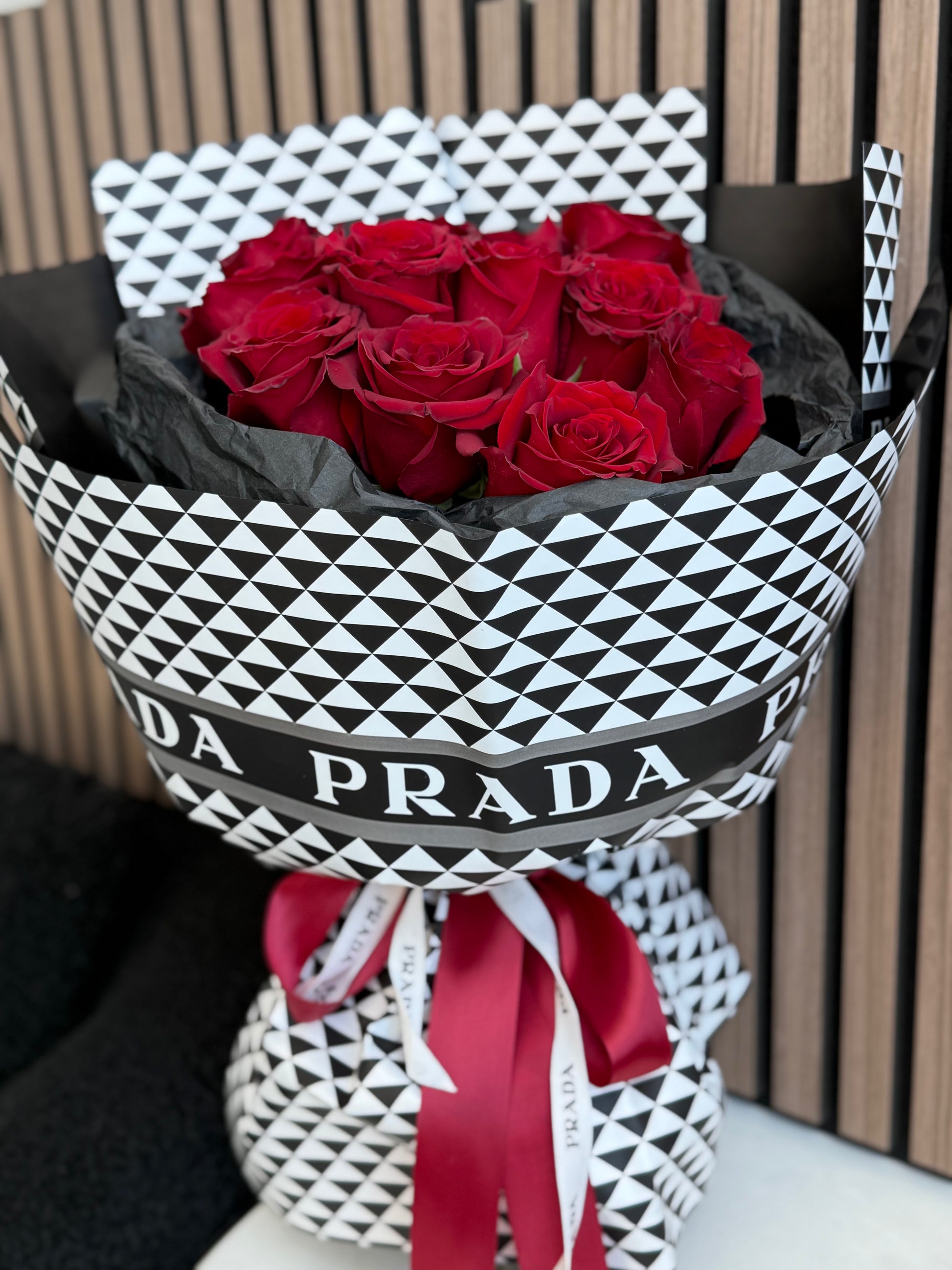 12 red roses bouquet in Prada-inspired black and white luxury wrap with red ribbon