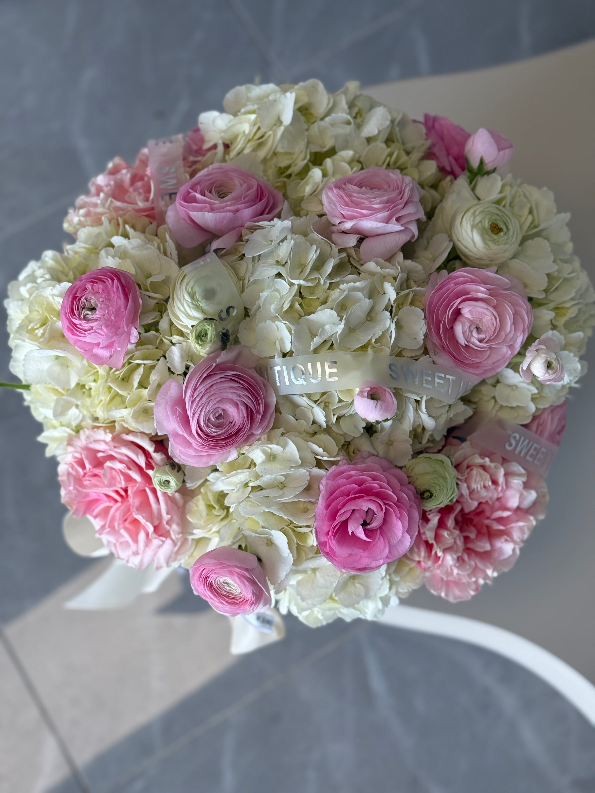 soft pink ranunculus hydrangea arrangement in woven basket elegant floral gift GTA
