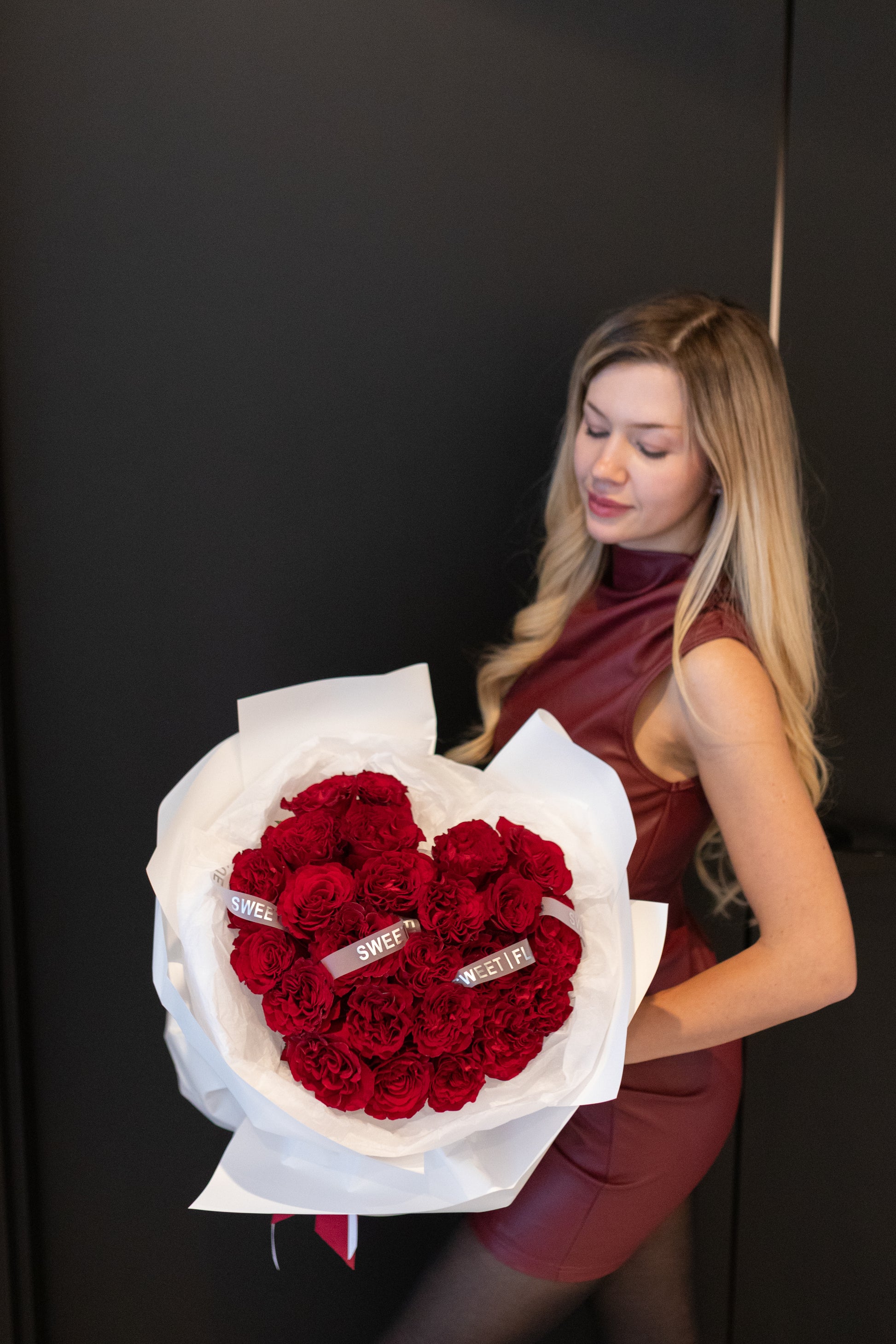 Woman holding red roses and carnations bouquet, elegant romantic flowers