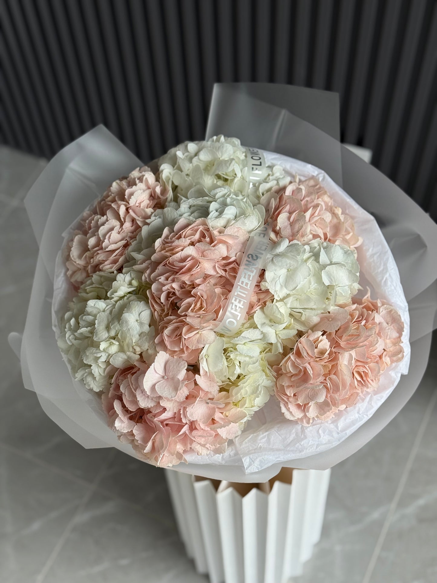 Bouquet of flowers in a white vase on a tiled floor