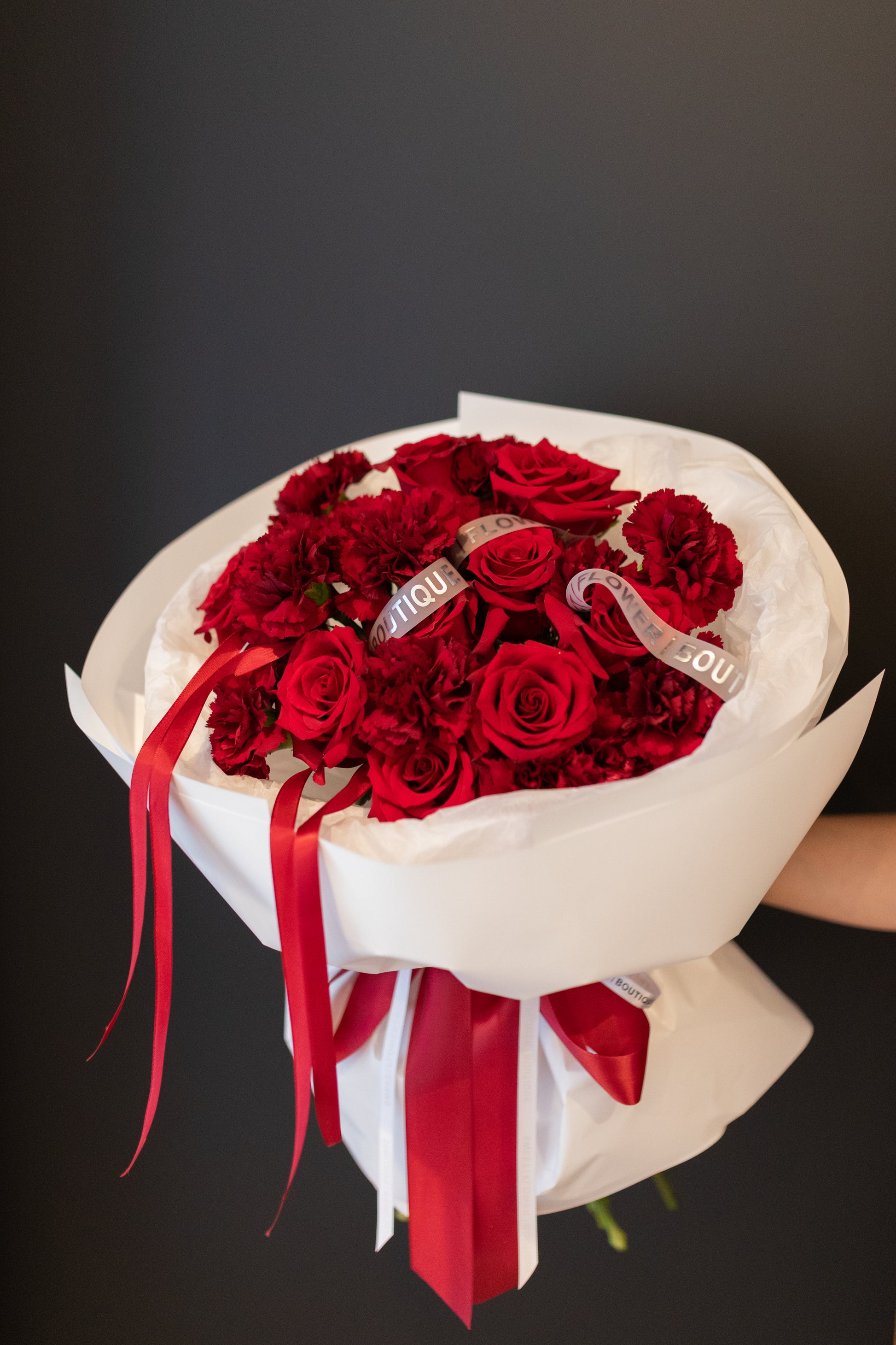 Close-up of red roses and carnations bouquet showing rich textures and full blooms